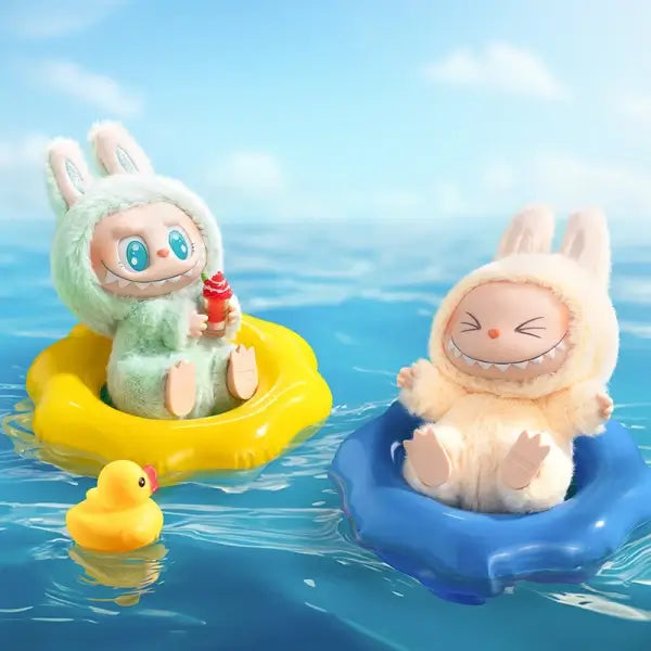Scene showing Popmart Labubu Have A Seat naes 'QUQU' and 'SISI' floating on inflatable rings in the water. QUQU is on a yellow ring with a small yellow rubber duck nearby, while SISI is on a blue ring.